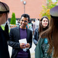 A man and a woman talking to two students wearing teekkari hats