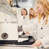 Students looking at a microscope smiling