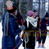 Artists from the peripheries in parallax research group take part in a performance: they hold a red string between them. They stand in a snowy forest.