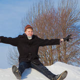 A happy student slides downhill a snowbank