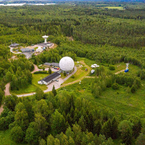 Metsähovin radio-observatorio kuvattuna lintuperspektiivistä. Vihreän metsämaiseman keskellä radio-observatorio.
