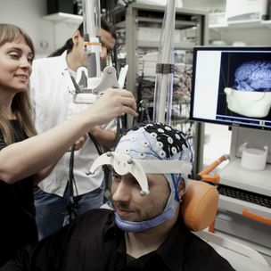 Researcher setting braing imaging receptors to a voluntary subject