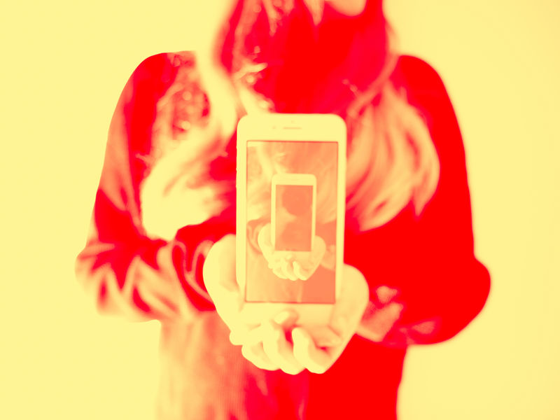Kuvituskuvassa ihminen pitelee puhelinta ja kuva toistuu puhelimen näytöllä. Kuvaaja: Jaakko Kahilaniemi.