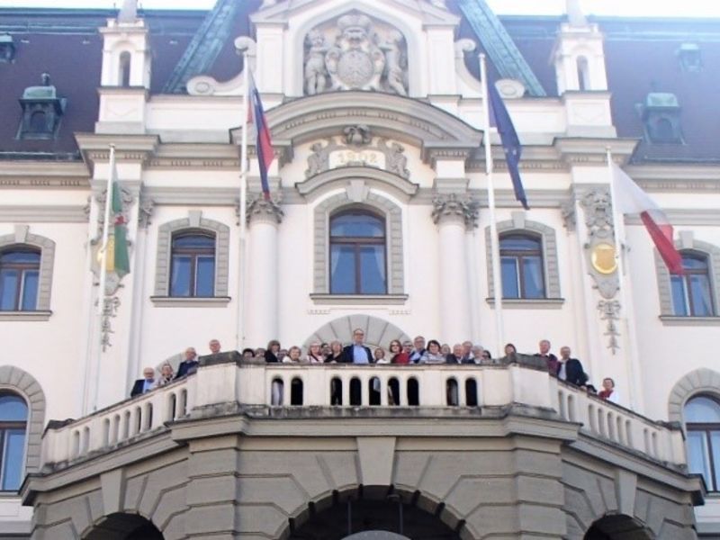 Ljubljanan yliopiston päärakennus ja seniorit kuuluisalla parvekkeella