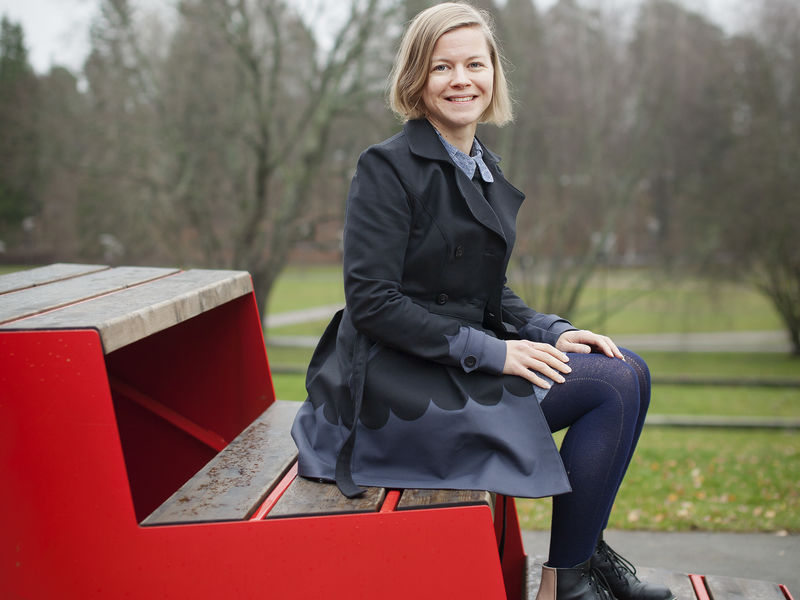 Marja Niemi istumassa portailla Aalto-yliopiston kampuksella. Kuva: Terhi Korhonen