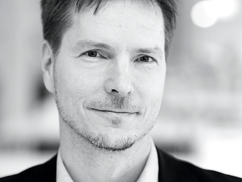 Black & white face image of smiling Matti Kuittinen.