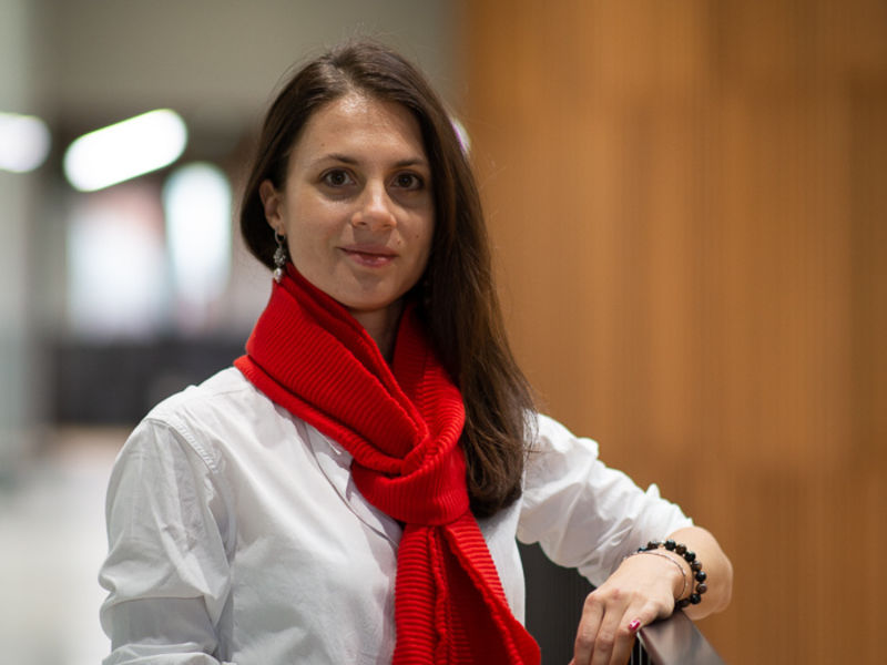Picture of Lidia Borisova She is wearing a white shirt and red scarf and is smiling towards the camera.