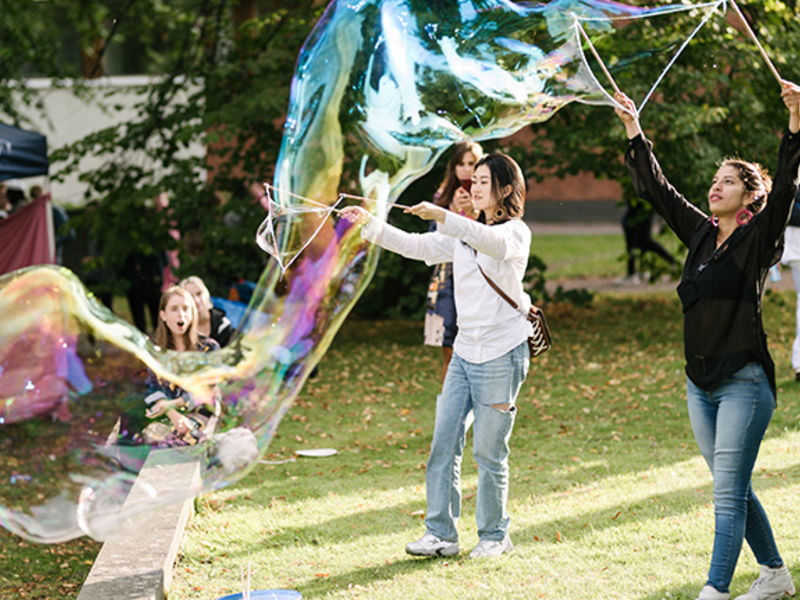 Students doing big soap bubbles in a party for semester start.