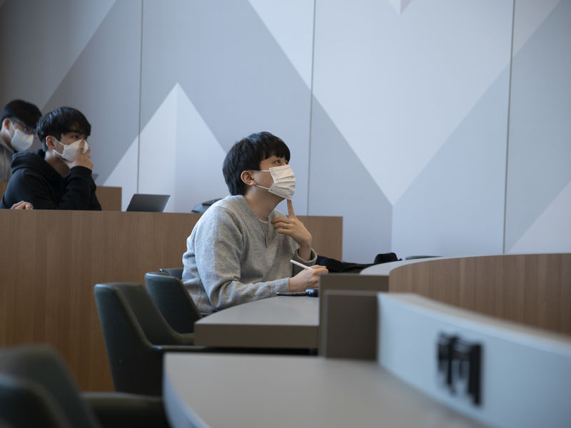 A student listening to a business lecture during a course by Aalto University International Program