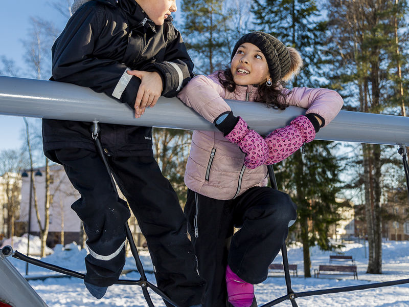 Two young children climbing at the playground