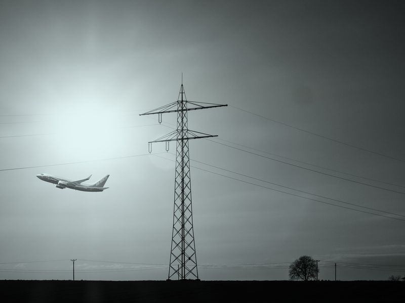 Airplane taking of with power lines in the foreground