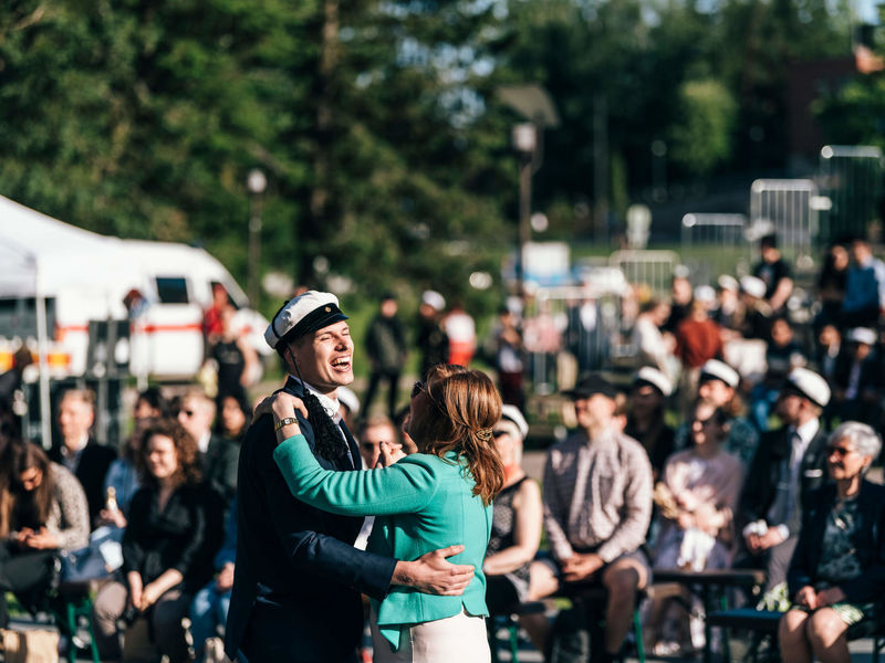 Two people laughing and dancing at Aalto University's graduation party. Photo: Jaakko Kahilaniemi / Aalto University
