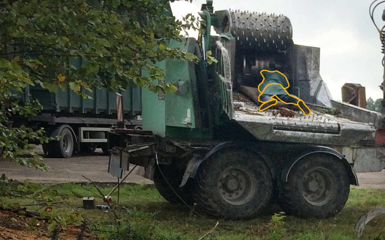 Photo of a leaf shredder with a man drawn over the photo as being crushed by the machine