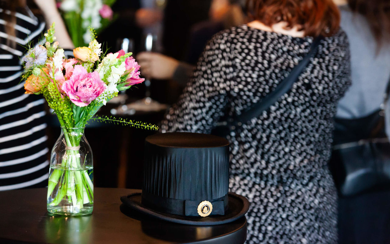 Tenured Professors' Installation Talks reception, doctoral hat and flowers in front of people