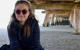 Aalto University / A girl sitting on sand with sunglasses on / Laura McLeod