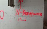 Image depicts a white wall with the words IV Konehuone OLO sprayed on it in red, referring that the engine room for AC is that way.