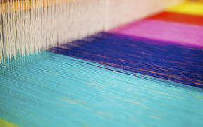 ARTS studio with a close-up on colourful yarns on a loom, image by Mikko Raskinen
