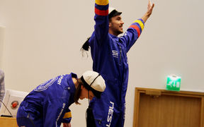 An image of two students wearing blue overalls