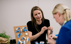 Kaksi naista tekemässä kankaisia rintamerkkejä. Kuva: Marko Oikarinen / Aalto-yliopisto