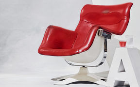 Red armchair next to an Aalto logo with glasses perched on top
