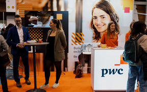 Smiling people standing in front of a colorful wall with PwC logo 