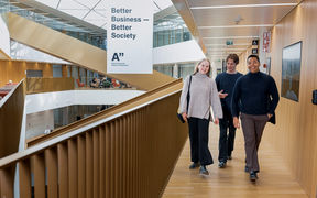 Three students walking and talking in a school corridor