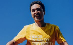 Happy student in a yellow Aalto University t-shirt