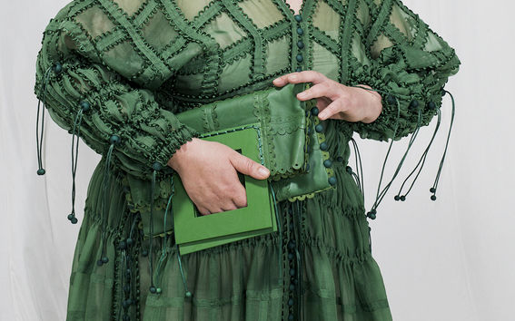 Kuvassa näkyy vihreää mekkoa ja vihreä käsilaukku.