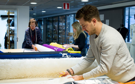 A man cutting fabric in the sewing workshop at Aalto University
