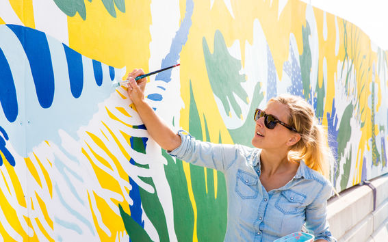 An Aalto student paints a wall for Flow Festival in Helsinki. AaltoXFlow photo: Mikko Raskinen / Aalto University