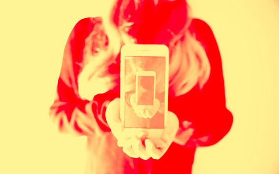 Kuvituskuvassa ihminen pitelee puhelinta ja kuva toistuu puhelimen näytöllä. Kuvaaja: Jaakko Kahilaniemi.