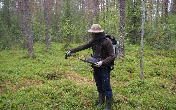 Remote sensing research team member conducting field measurements of plant spectra and forest structure