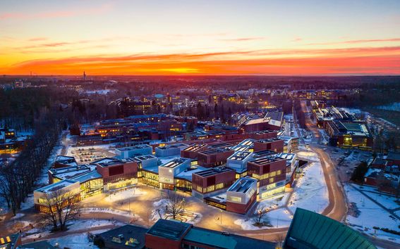 Ilmakuva Väreestä ja Kauppakorkeakoulusta. Taivas upean punakeltainen. Kuva: Aalto-yliopisto / Mika Huisman