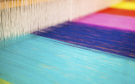 Colourful yarns on a loom in an Aalto University studio facility
