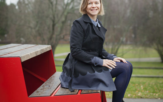 Marja Niemi istumassa portailla Aalto-yliopiston kampuksella. Kuva: Terhi Korhonen