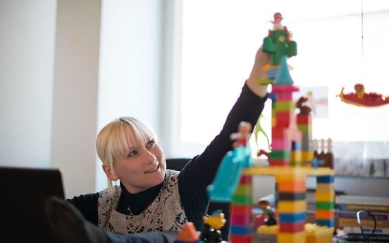 Pauliina Ilmonen rakentaa tornia lego-palikoista kuvattuna työhuoneessaan. Kuva: Heidi-Hanna Karhu.