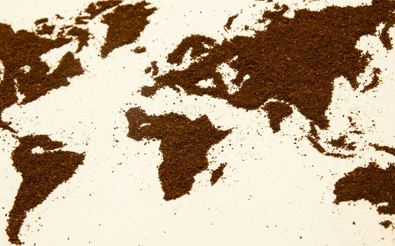 tasaiselle vaalealle pinnalle on muodostettu maailmankartta kahvijauheesta