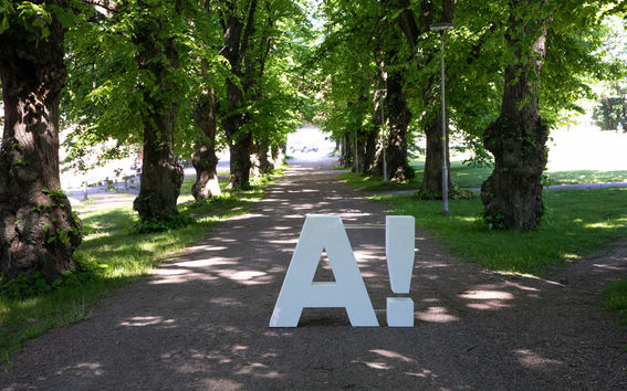 Aalto logo placed at campus on green pathway, photo by Mikko Raskinen 