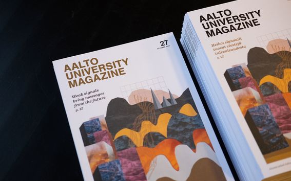 Aalto University Magazine 27 -lehden englanninkielisiä ja suomenkielisiä numeroita vierekkäin pöydällä. Kuva: Anni Kääriä.