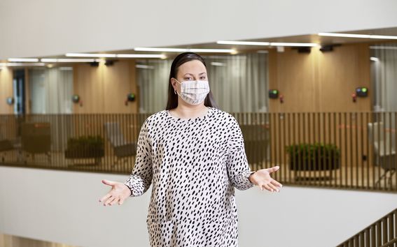 Picture of Head of Summer School Laura Sivula in a face mask and a white dress with black dots.
