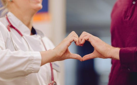 Doctor patient encounter with hands forming a heart