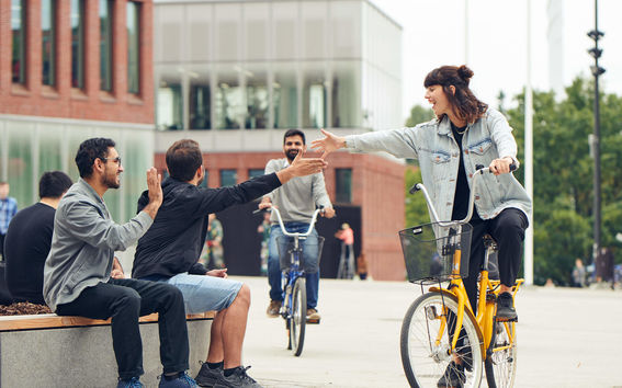 Students high-five-ing in front of the campus
