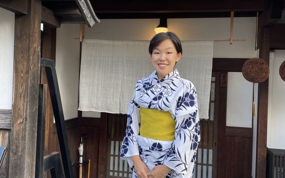 Chisako Ogiwara, Aalto University Digital Business Master Class alumna in a white kimono with blue flowers, standing and smiling into the camera.