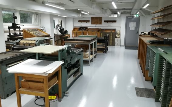 A printshop space with letterpress machines and typeface drawers, from printmaking workshop