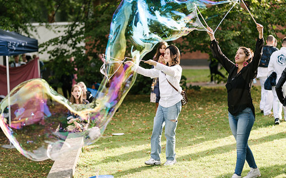 Students doing big soap bubbles in a party for semester start.