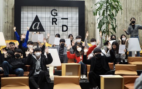Group picture of students from UNIST university holding their diplomas and wearing face masks in A Grid building, Aalto University.