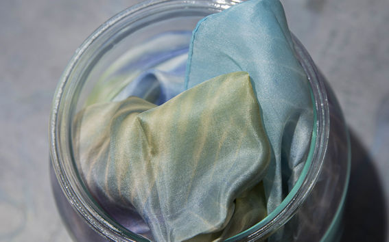 Colored silk fabric in a glass jar 
