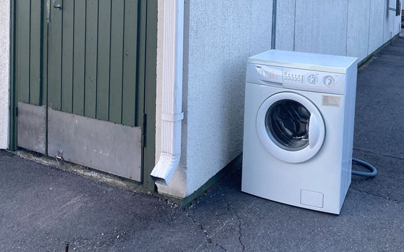 A photo of a corner with a door and a washing machine.
