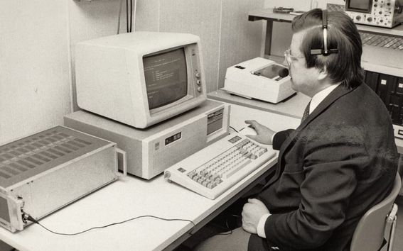 Mustavalkoisessa arkistokuvassa Teuvo Kohonen istuu vanhanaikaisen tietokoneen äärellä.