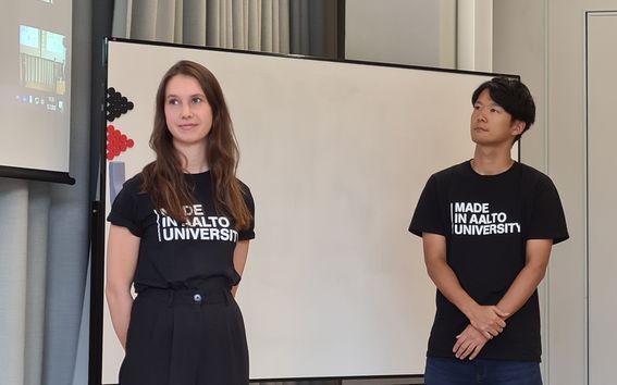 Liva Gramlow and a fellow student in black Aalto University presentation holding a presentation during the Digital Business Master Class by Aalto University Summer School.